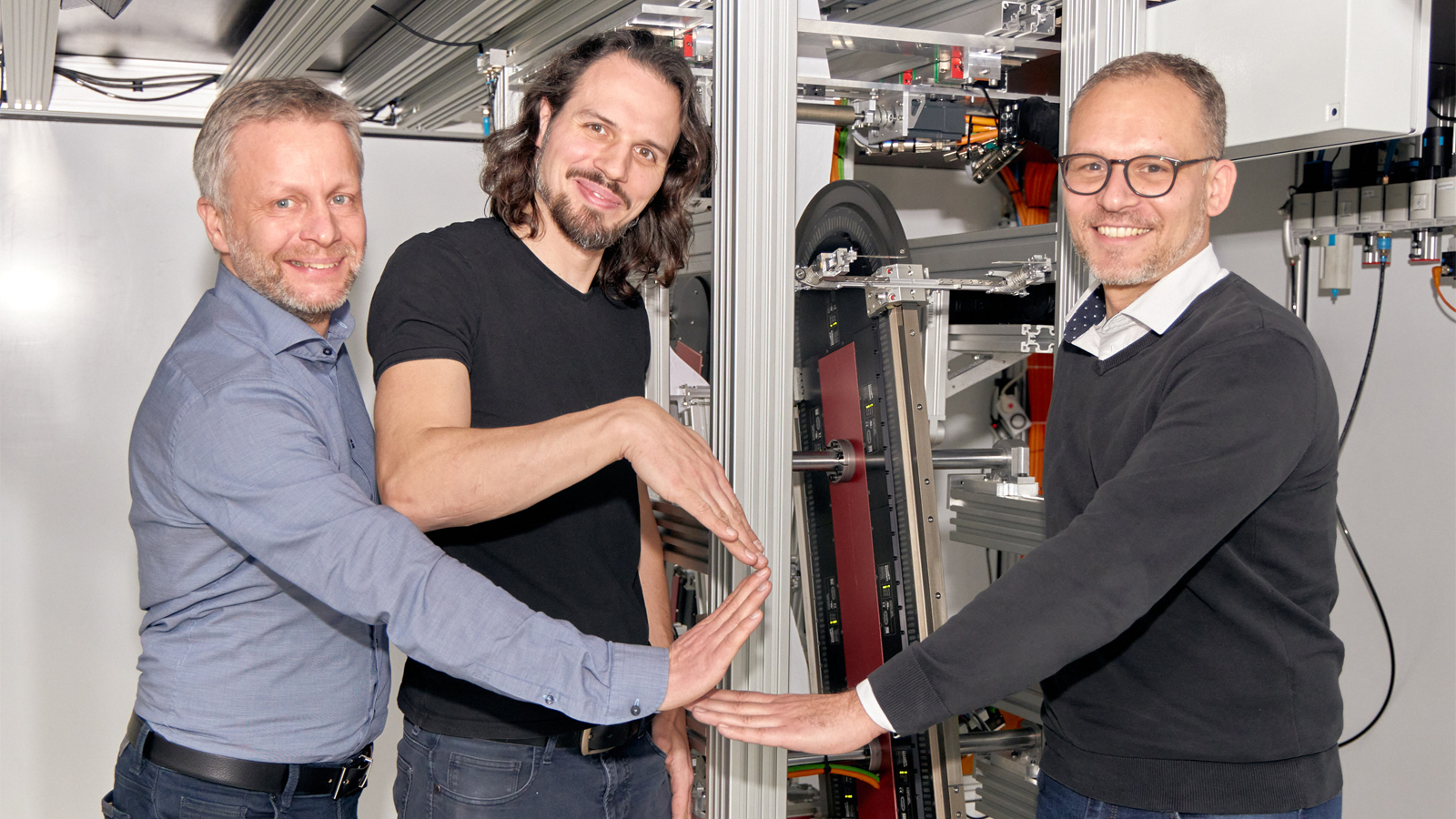 正在演示 Z 型叠片装置（从左到右）：倍福柏林分公司销售工程师 Guido Sieder；柏林工业大学机床与工厂管理研究所（IWF）搬运和装配技术部高级研究员 Arne Glodde；以及倍福应用工程师 Mathias Arndt  